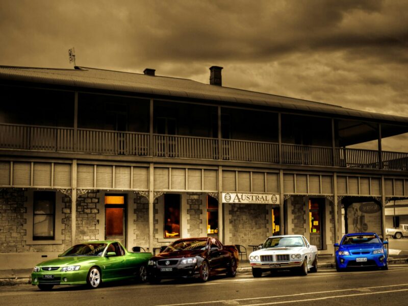 A view of The Austral Inn Hotel with four cars parked in front of the venue