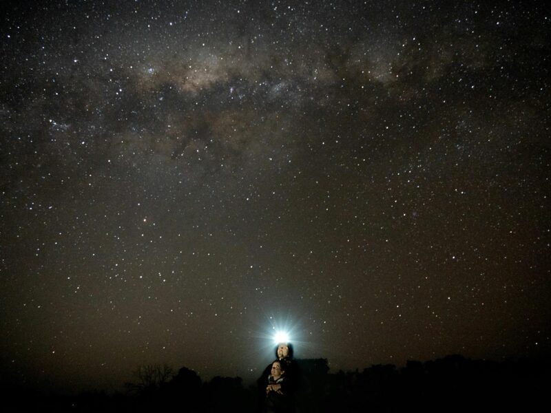 A guest looking at the dark night sky with a headtorch on