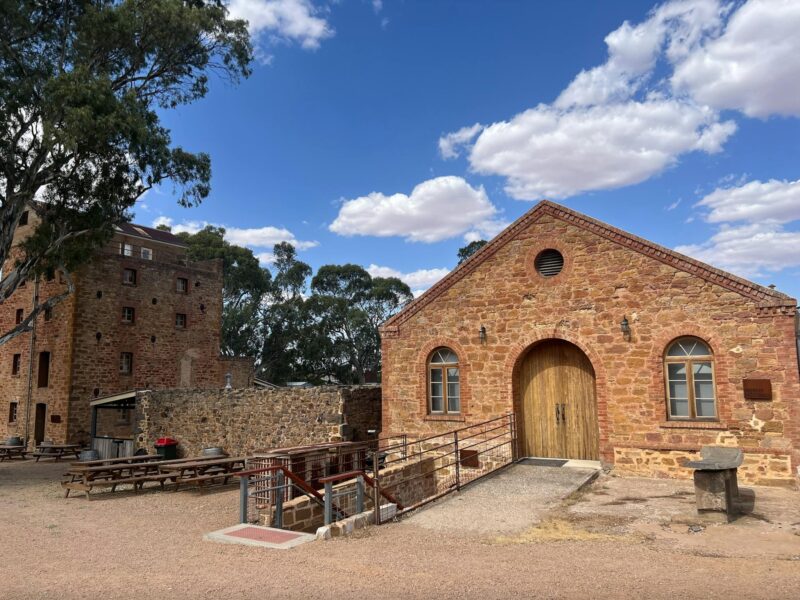 a historic old shearing building with an old but renovated brewery tower in the background